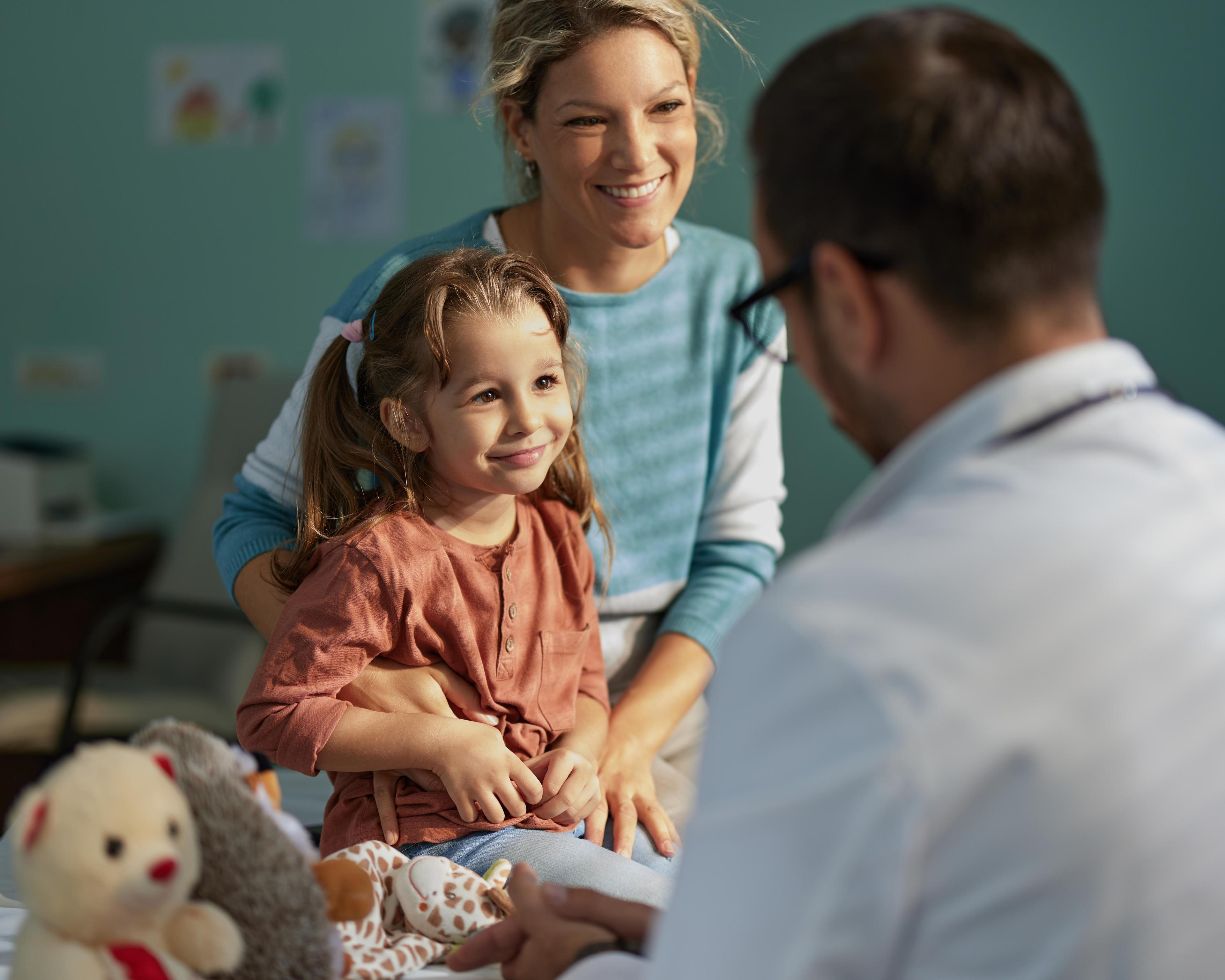 Smiling girl having an appointment with her mother at pediatricians 1535569562.jpg