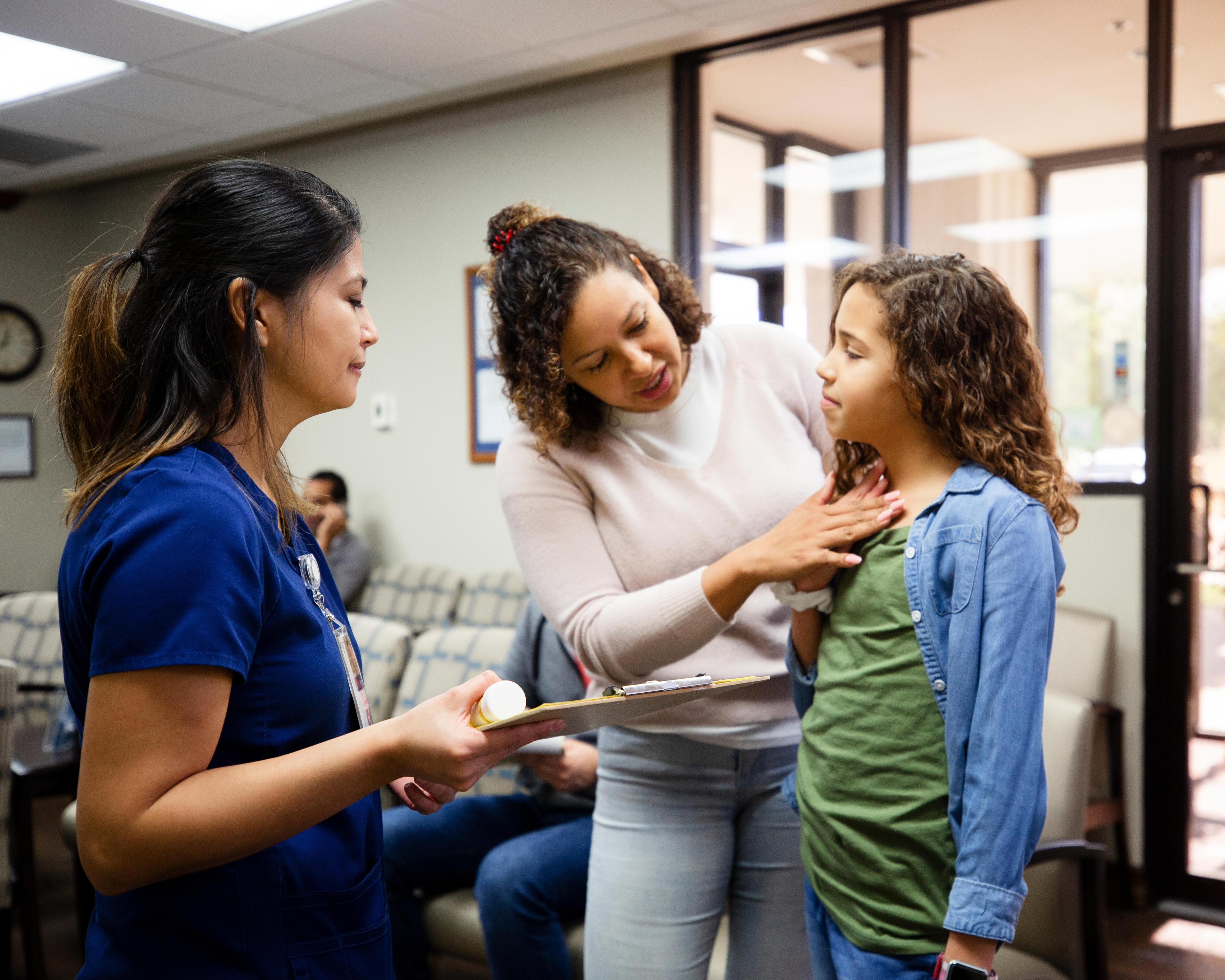 Mother discusses daughters symptoms with nurse 1207513987.jpg